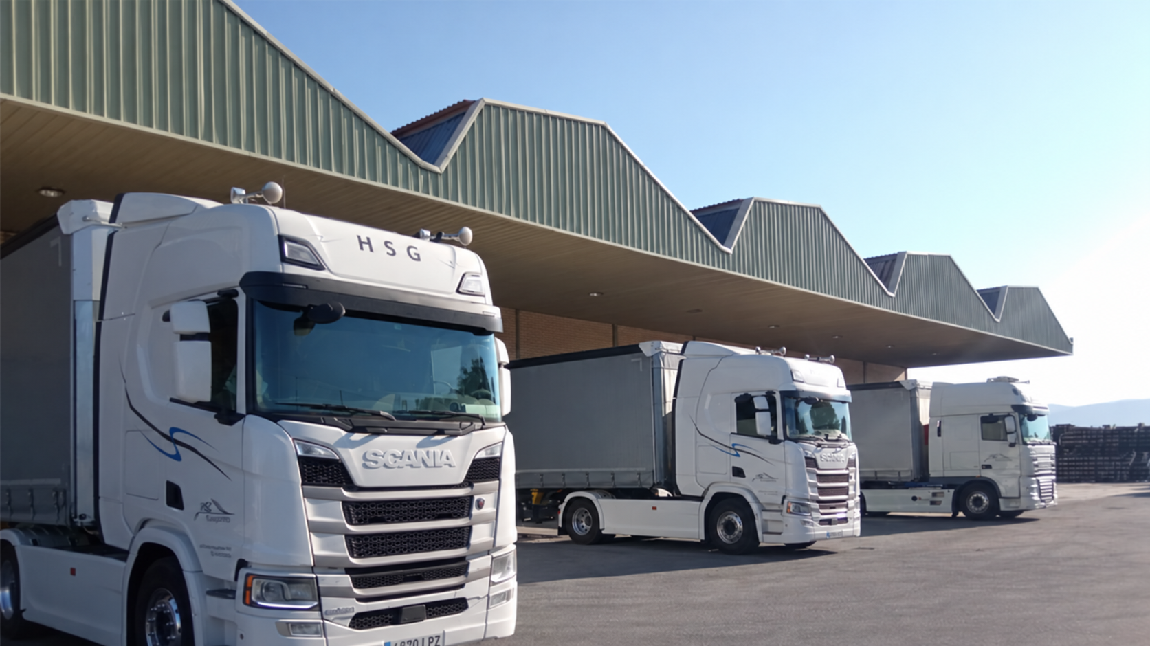 Tres camiones de HSG Transportes junto a las naves